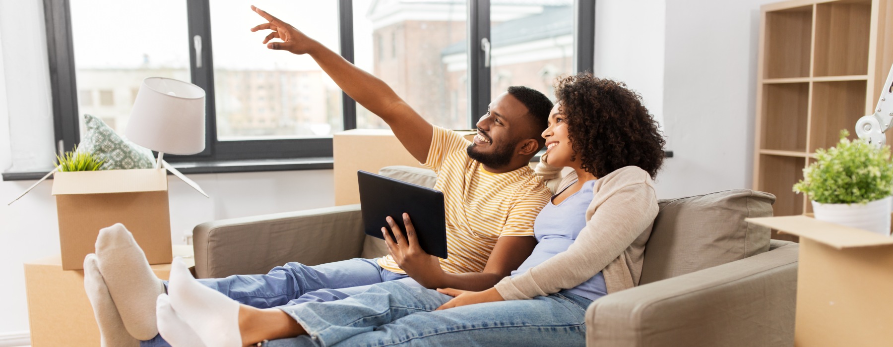 Residents browsing community features on a laptop in a modern apartment living room