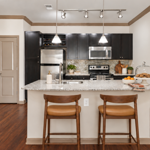 Open-concept kitchen and dining area featuring espresso cabinetry and stainless steel appliances at Stone Pointe Apartments in Woodbridge, VA