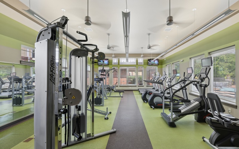 On-site fitness center at Stone Pointe apartments featuring treadmills, exercise bikes, and weight training strength equipment.